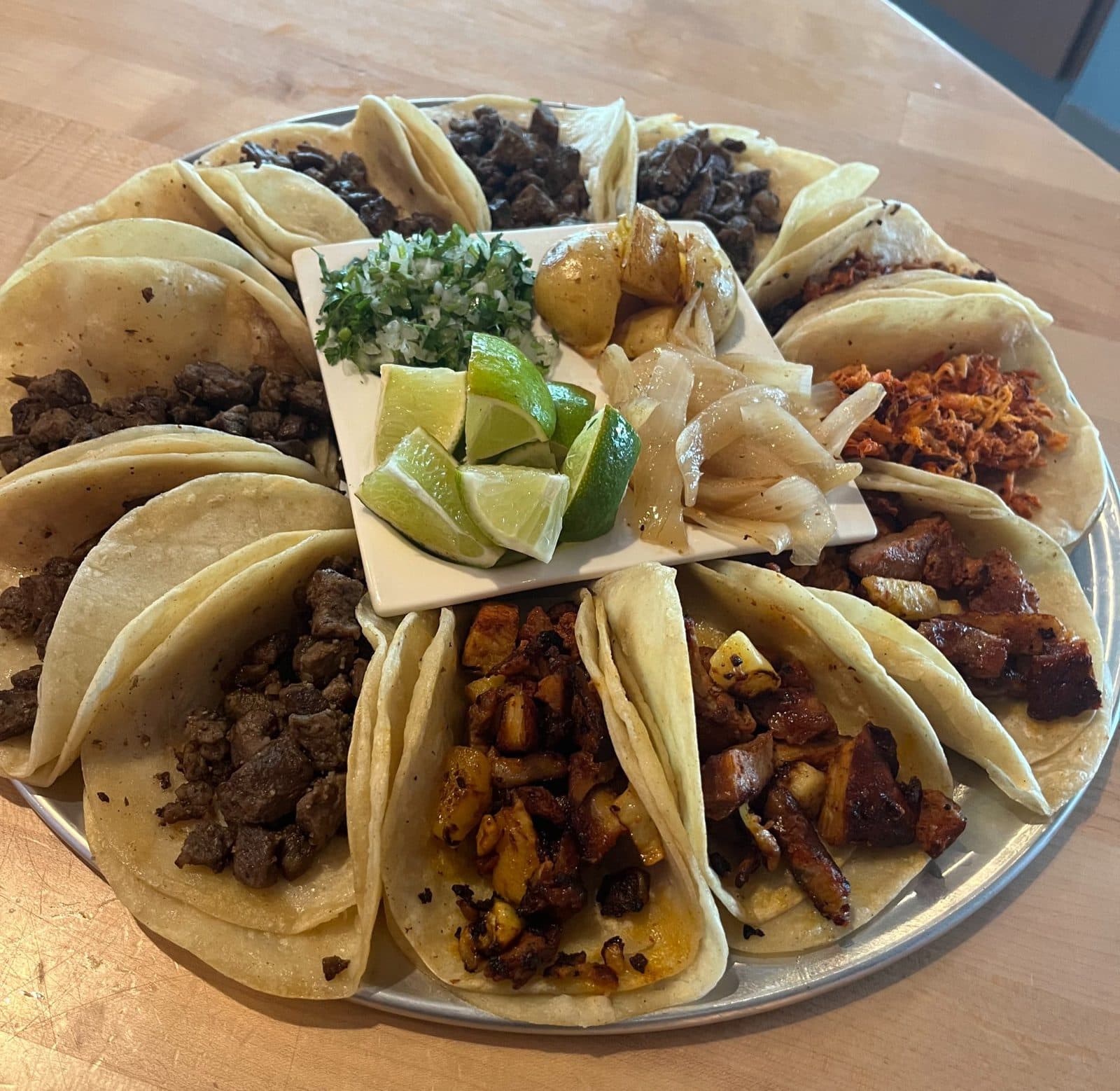 A platter of street tacos with lime at Faustinos