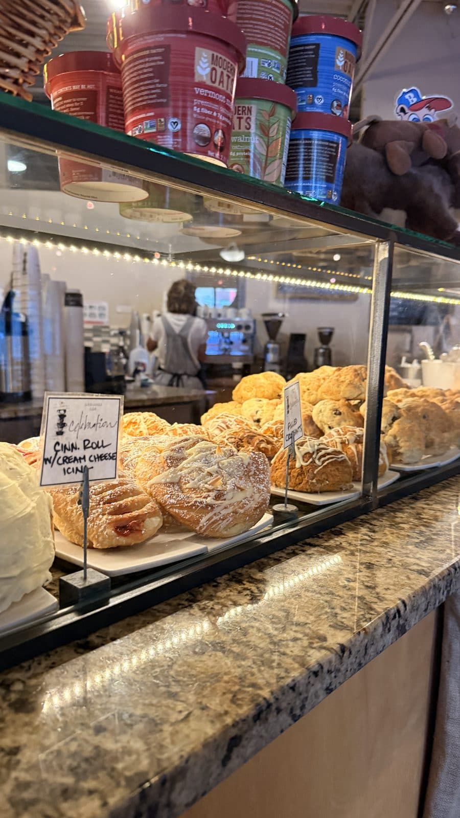 Pastry case with cinnamon rolls and baked goods at Grounds for Celebration