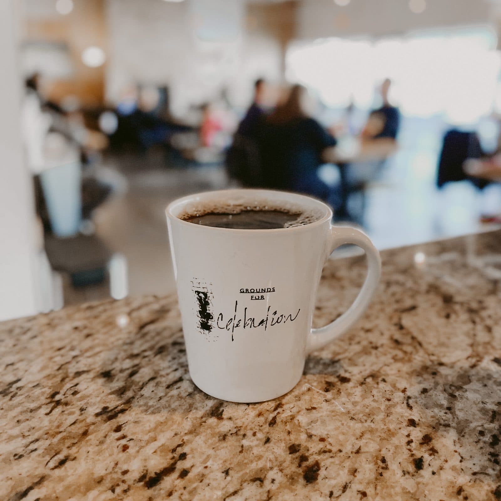 A Grounds for Celebration mug of coffee on a granite counter